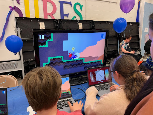A group of children sit at a TV screen, playing Rock Hunting with Mohs. They are conducting a scratch test using the finalized version of the scene.